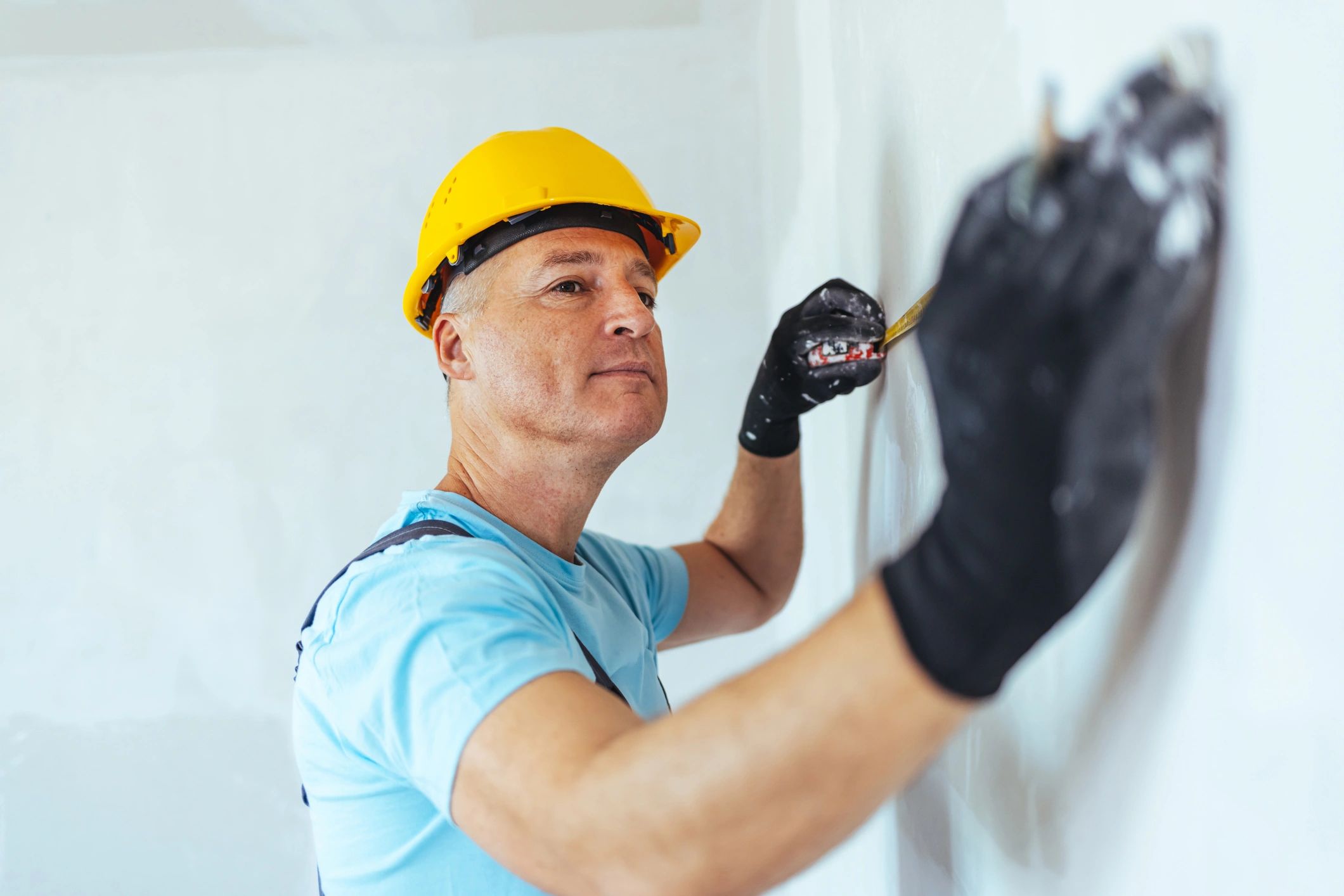 Renovation professional measuring for cabinetry during a remodel